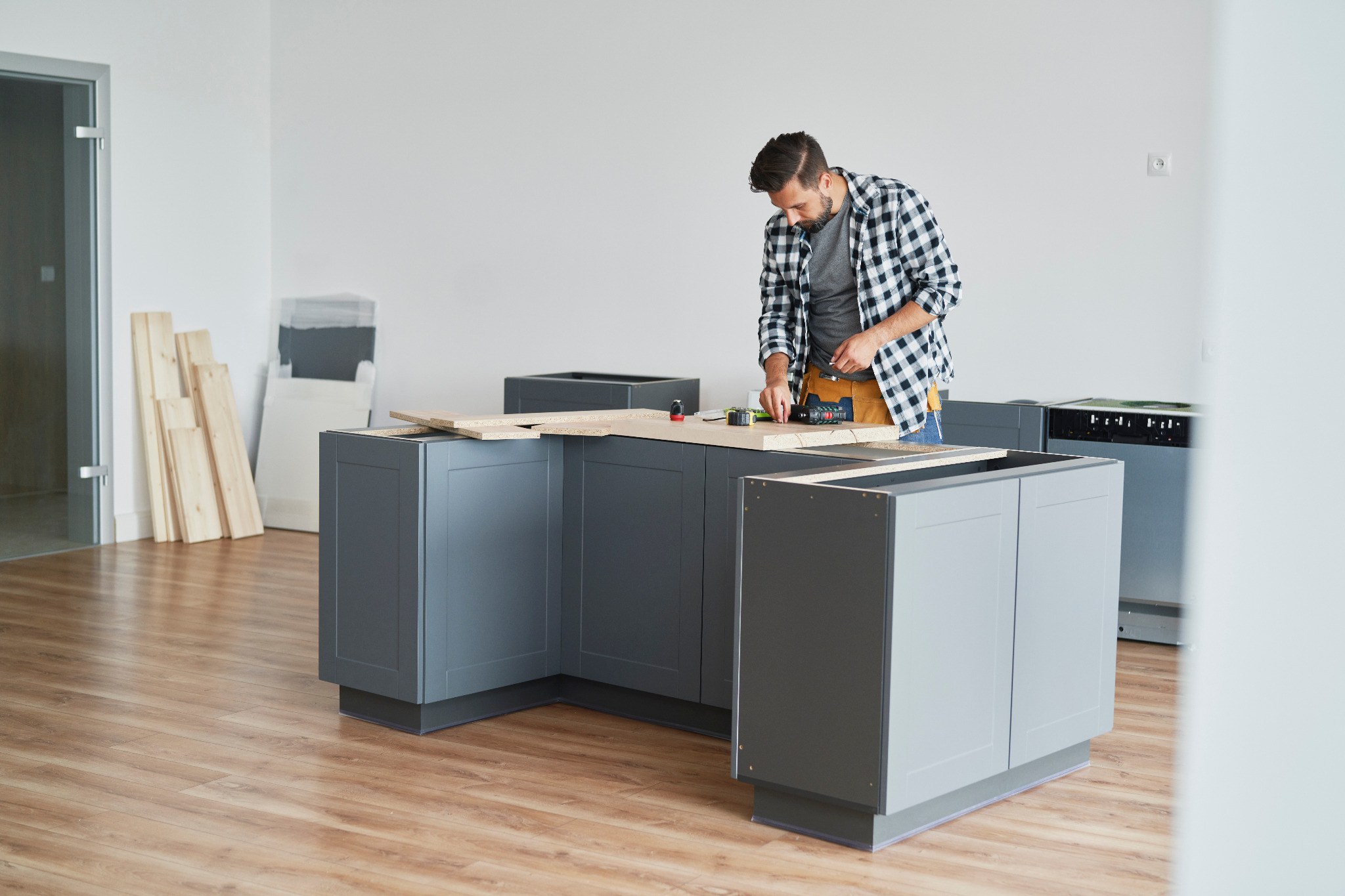 Carpenter assembling fitted kitchen cabinets